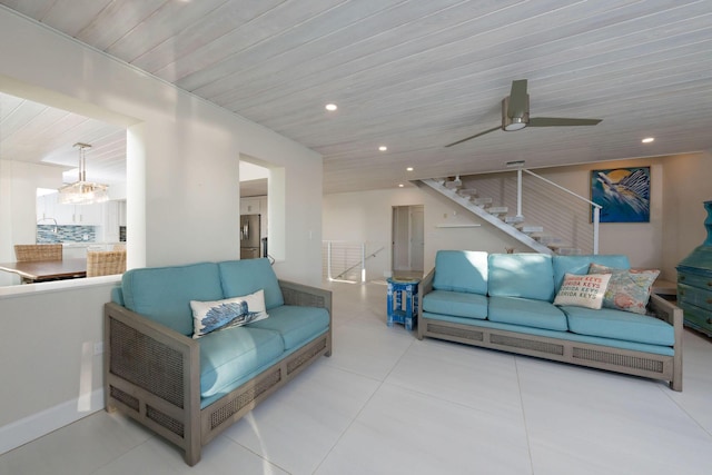 tiled living room with wood ceiling and ceiling fan with notable chandelier