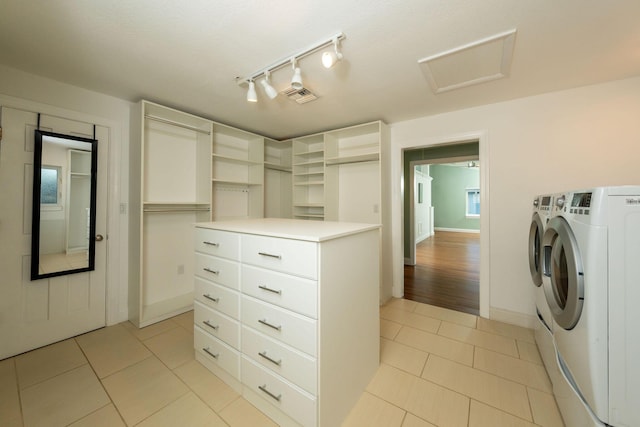 laundry area with light tile patterned flooring, rail lighting, and washing machine and clothes dryer