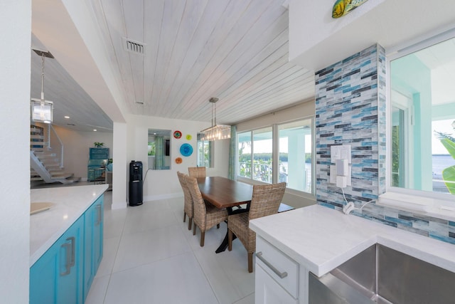 dining area featuring an inviting chandelier, wooden ceiling, and light tile patterned floors