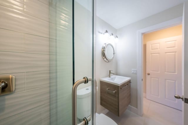 bathroom featuring tile patterned flooring, vanity, an enclosed shower, and toilet