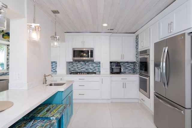 kitchen featuring sink, white cabinetry, light tile patterned floors, appliances with stainless steel finishes, and backsplash