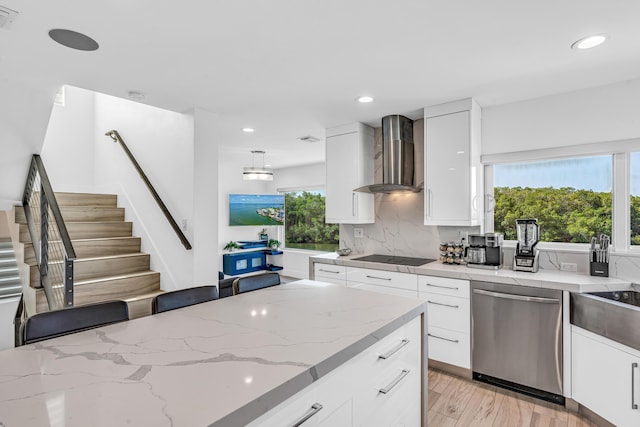 kitchen with tasteful backsplash, modern cabinets, stainless steel dishwasher, light stone countertops, and wall chimney exhaust hood