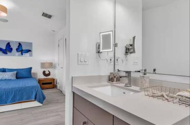 bathroom featuring visible vents, vanity, and wood finished floors