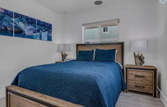 bedroom featuring baseboards and wood finished floors