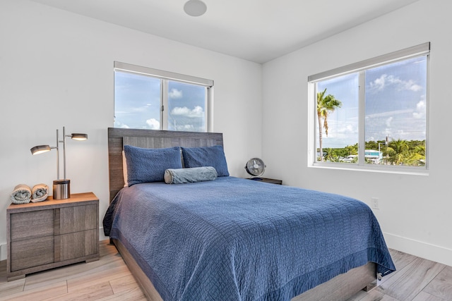 bedroom with light wood-type flooring and baseboards