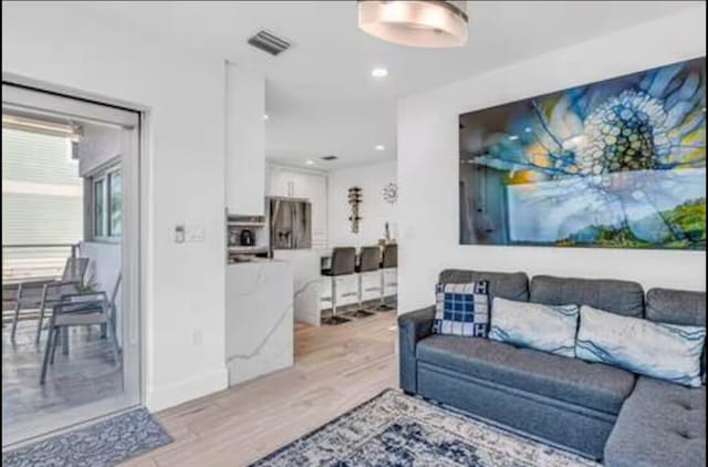 living area featuring visible vents and light wood-style flooring