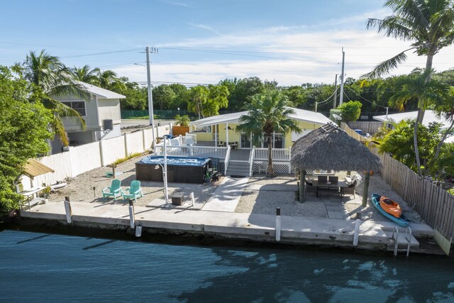 dock area featuring a gazebo, a hot tub, and a patio area