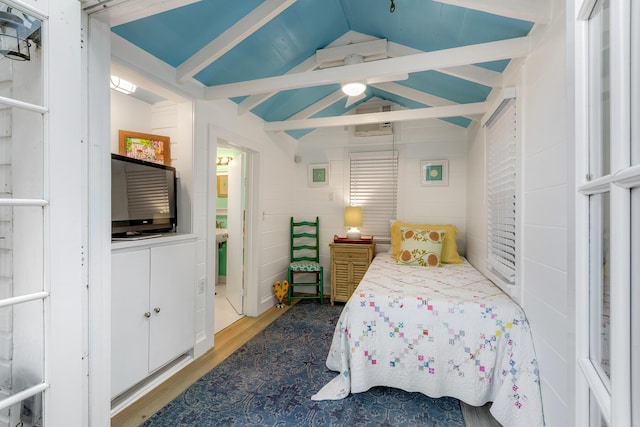 bedroom featuring vaulted ceiling with beams, light wood-type flooring, and a ceiling fan