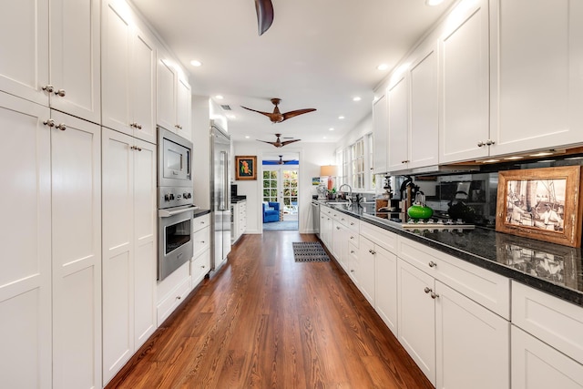 kitchen featuring dark wood finished floors, recessed lighting, a ceiling fan, white cabinets, and built in appliances