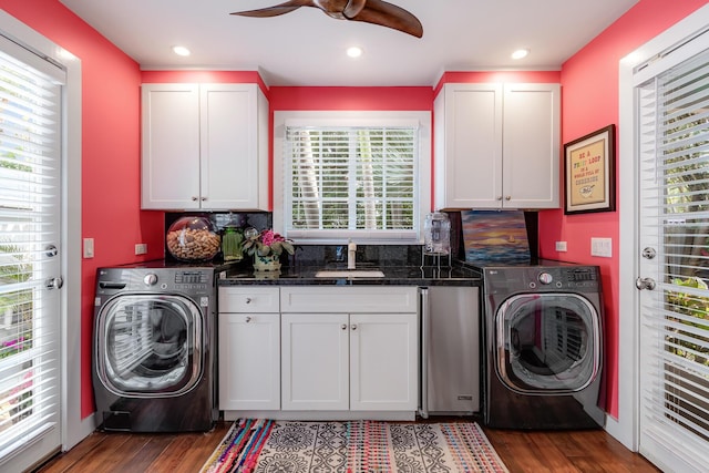 washroom with wood finished floors, cabinet space, a sink, and washer / dryer