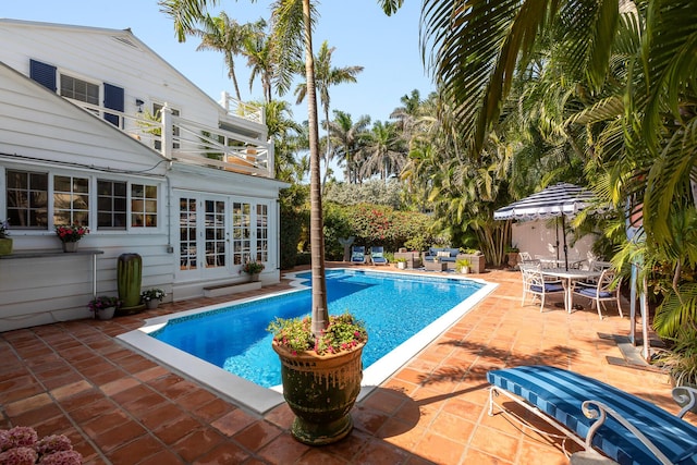 pool with a patio, french doors, and outdoor dining space