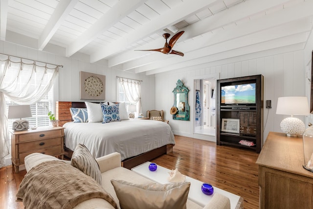 bedroom featuring ceiling fan, beamed ceiling, wood finished floors, and baseboards