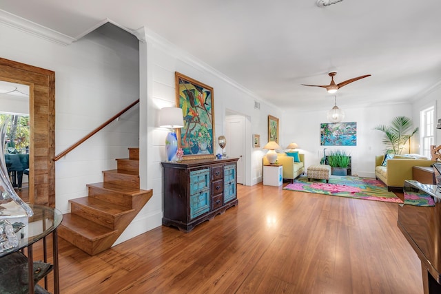 interior space with stairs, ornamental molding, wood-type flooring, and a healthy amount of sunlight