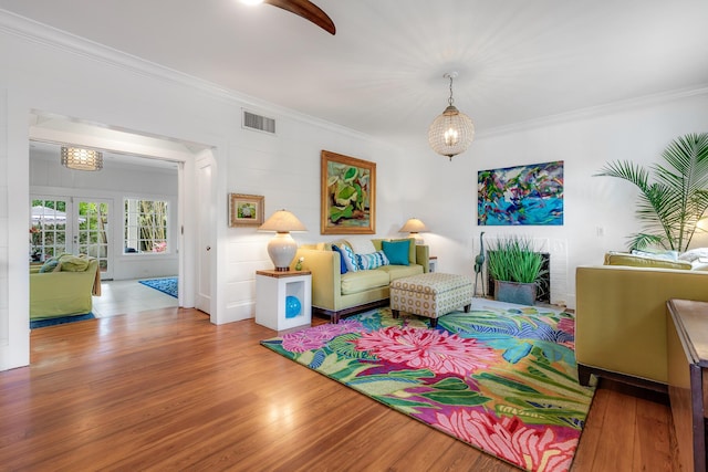 sitting room with visible vents, french doors, wood finished floors, and ornamental molding