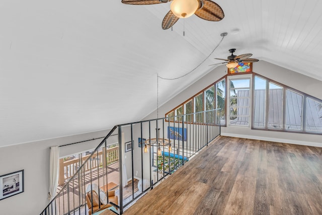 staircase featuring ceiling fan, wood-type flooring, and vaulted ceiling