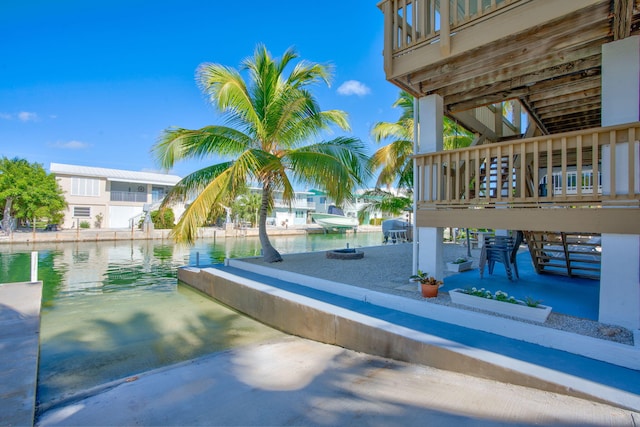 exterior space with a grill, a boat dock, and a water view