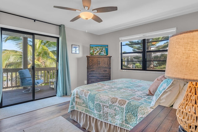 bedroom featuring multiple windows, hardwood / wood-style flooring, access to outside, and ceiling fan