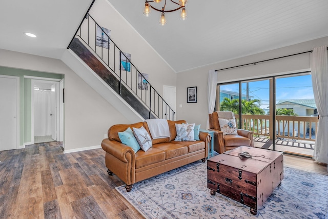 living room featuring lofted ceiling, wood-type flooring, and a chandelier