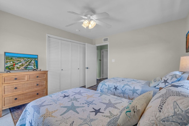 bedroom with ceiling fan, dark hardwood / wood-style flooring, and a closet