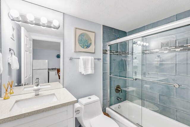 97501 Overseas Hwy Unit 705, Key Largo, FL 33037 - full bathroom featuring a textured ceiling, vanity, toilet, and bath / shower combo with glass door