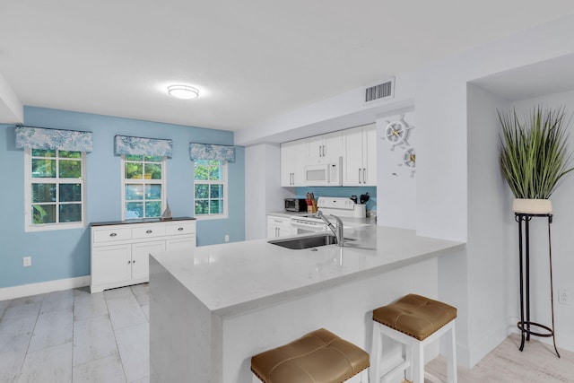 97501 Overseas Hwy Unit 705, Key Largo, FL 33037 - kitchen featuring a peninsula, white appliances, a sink, and white cabinets