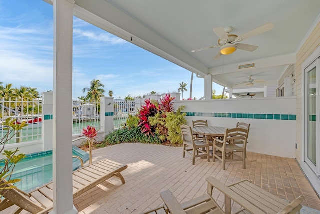 view of patio featuring a water view and ceiling fan