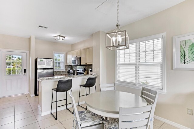 dining space featuring an inviting chandelier and light tile patterned floors