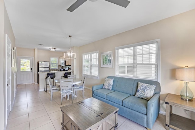 tiled living room featuring ceiling fan and a healthy amount of sunlight