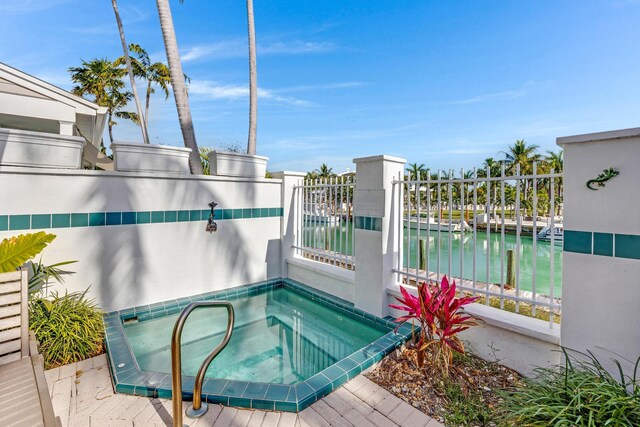 view of pool with an in ground hot tub and a water view