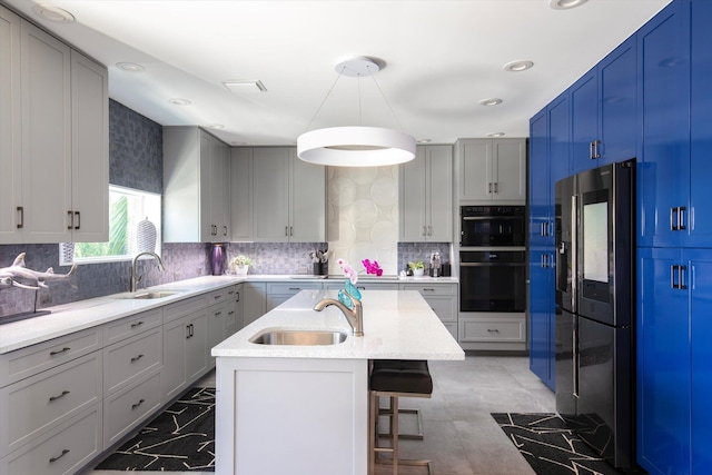 22 Floral Ave, Key Haven, FL 33040 - kitchen featuring sink, stainless steel fridge, pendant lighting, black double oven, and a kitchen island with sink