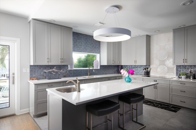 22 Floral Ave, Key Haven, FL 33040 - kitchen with sink, a center island with sink, backsplash, and gray cabinetry