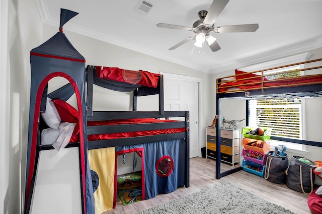 bedroom with ornamental molding, ceiling fan, and wood-type flooring