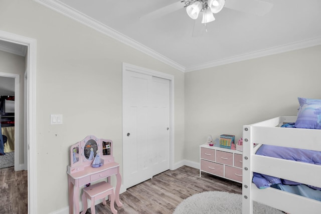 bedroom featuring hardwood / wood-style flooring, ceiling fan, a closet, and ornamental molding