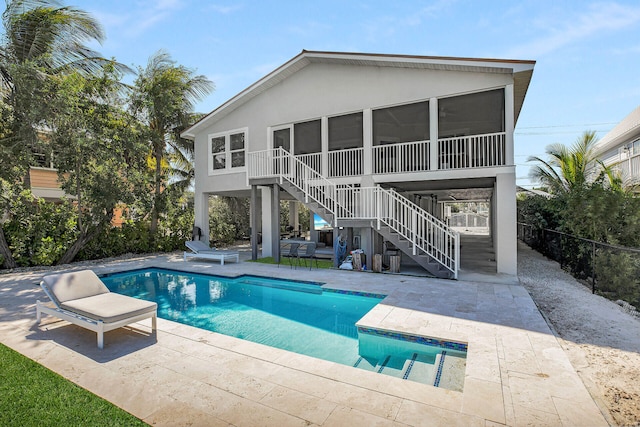 rear view of house with a patio area, a fenced in pool, and a sunroom