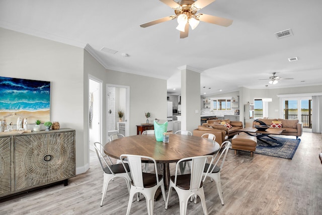 dining area featuring light wood-type flooring, ceiling fan, and ornamental molding