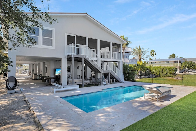 view of pool with a patio area, a hot tub, and a sunroom