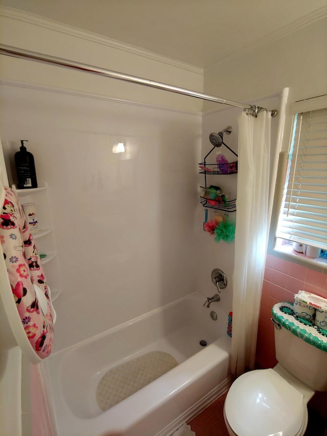 bathroom featuring shower / tub combo, toilet, and tile walls