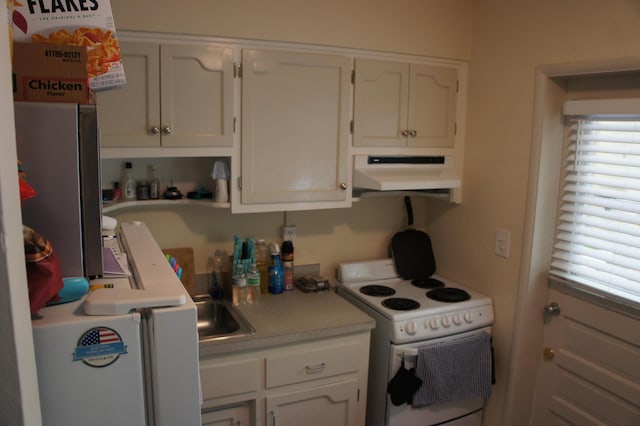 kitchen featuring electric stove and white cabinetry