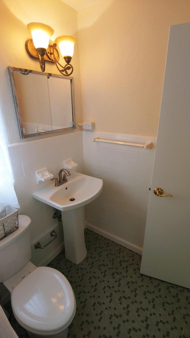 bathroom featuring tile walls and toilet