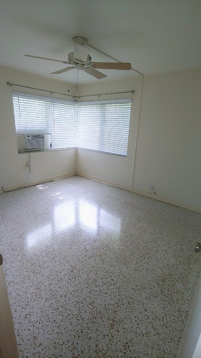 empty room featuring cooling unit and ceiling fan