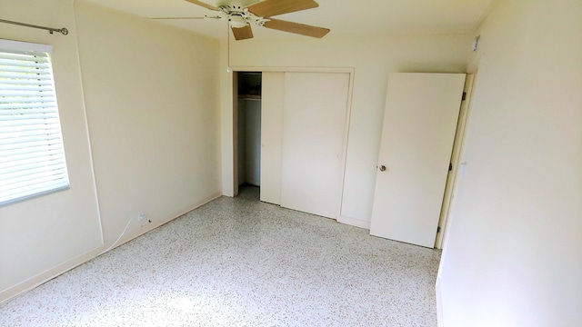 unfurnished bedroom with multiple windows, ceiling fan, and a closet