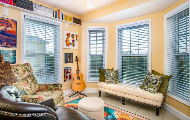 living area with a baseboard heating unit and tile patterned floors