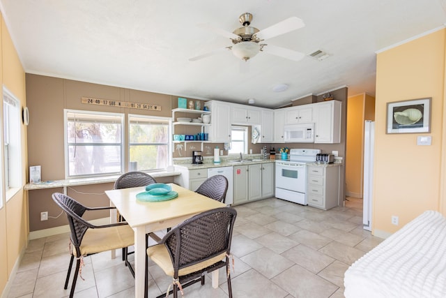 kitchen with lofted ceiling, white appliances, light tile patterned floors, ceiling fan, and white cabinets