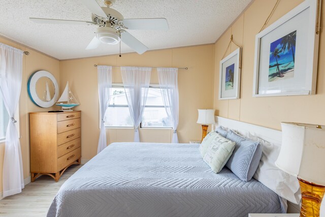 bedroom featuring ceiling fan, a textured ceiling, and light hardwood / wood-style flooring