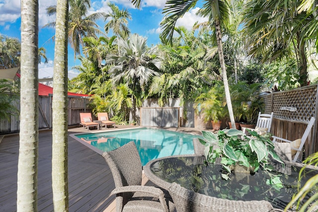 view of swimming pool featuring a deck, a fenced backyard, and a fenced in pool