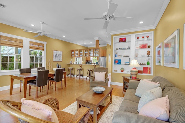 living room with light wood finished floors, recessed lighting, crown molding, and visible vents