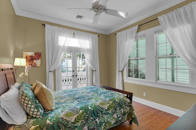 bedroom featuring multiple windows, crown molding, wood finished floors, and access to outside