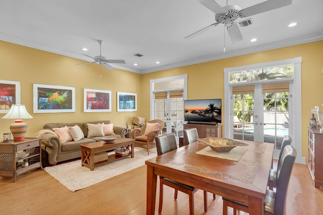 dining area featuring french doors, light wood finished floors, crown molding, and visible vents