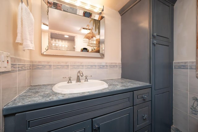 bathroom featuring vanity and tile walls