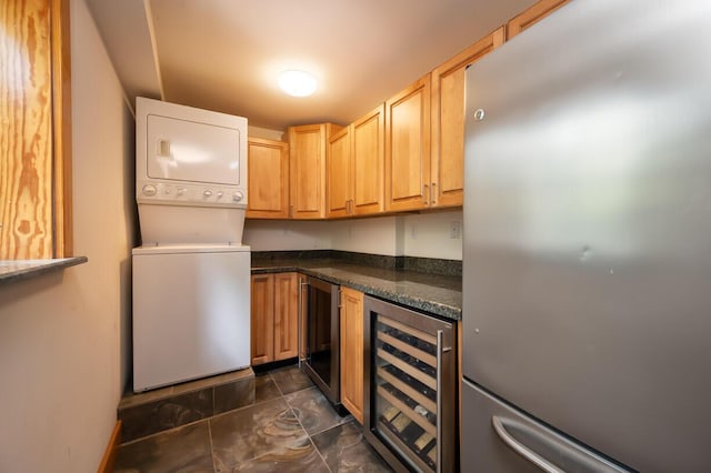 kitchen featuring stacked washer / dryer, light brown cabinets, beverage cooler, and stainless steel refrigerator